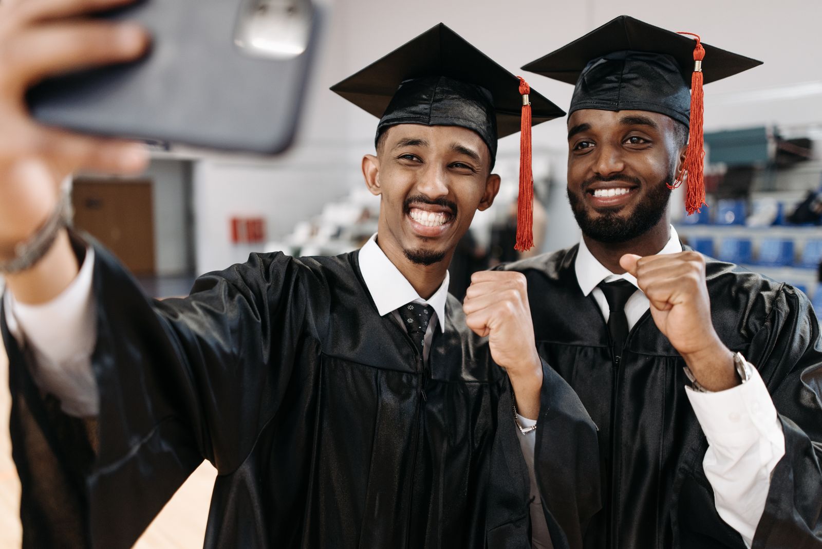 Deux jeunes diplômés en toge et toque célèbrent leur réussite